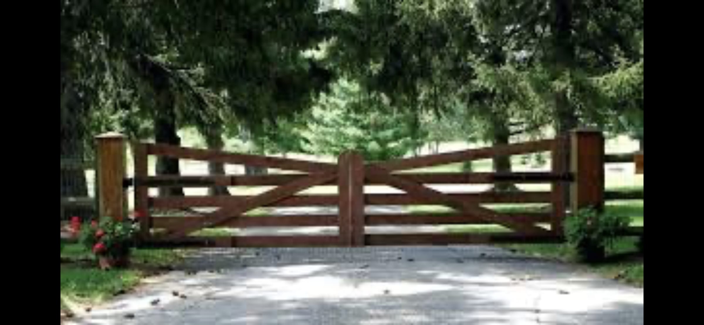 White contemporary double driveway gate with angled top rails and spindle infill plus matching pedestrian gate between stone pillars
