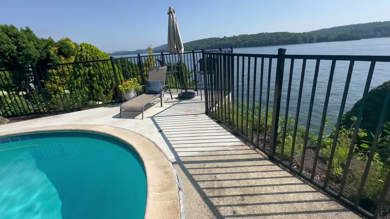 Black aluminum pool enclosure fence beside an in-ground pool
