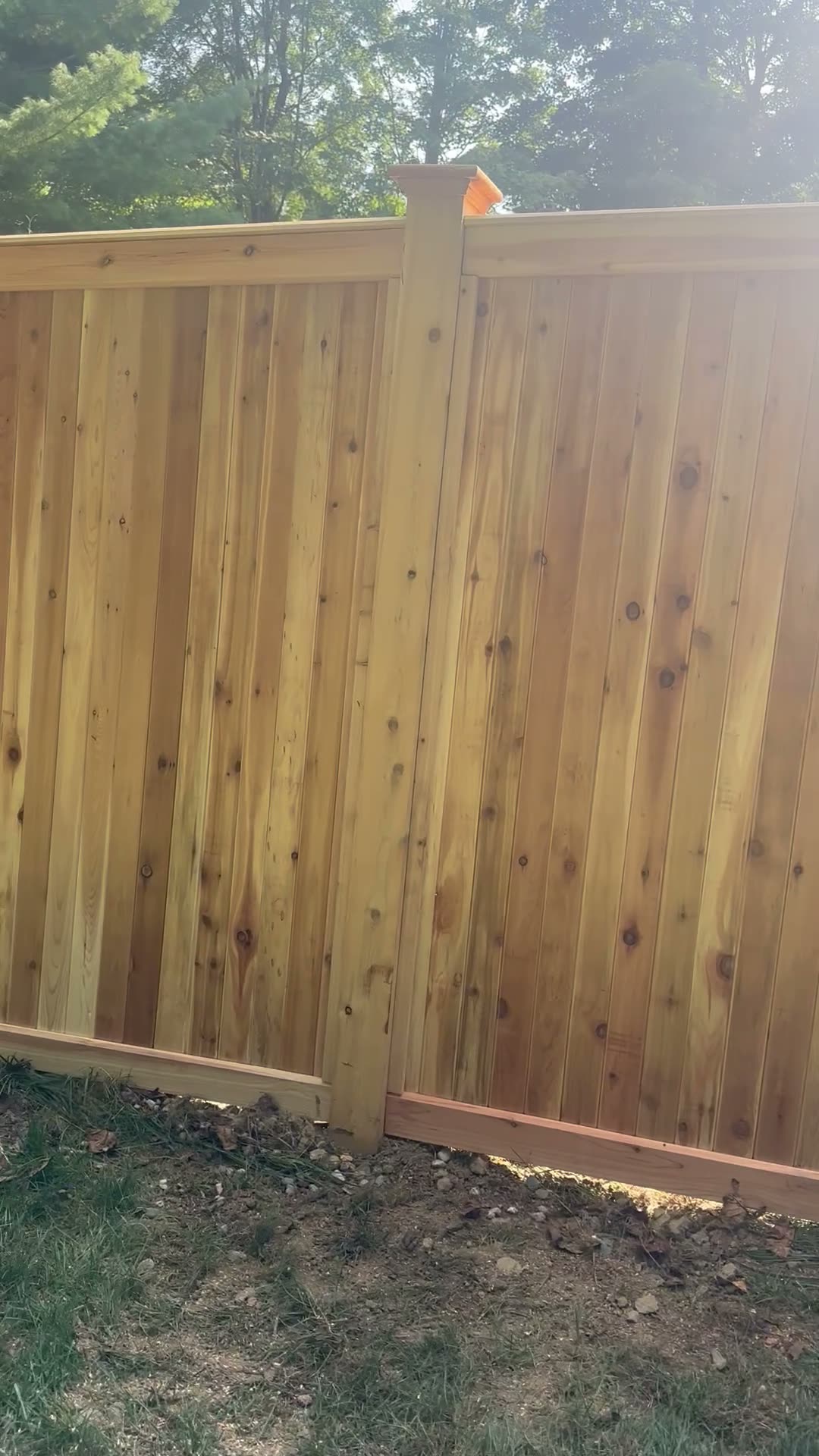 Cedar privacy fence corner with a gate latch and post cap