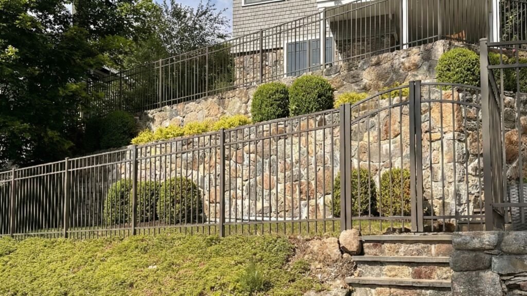 Completed residential fence installation on a sloped yard with restored landscaping and stair access