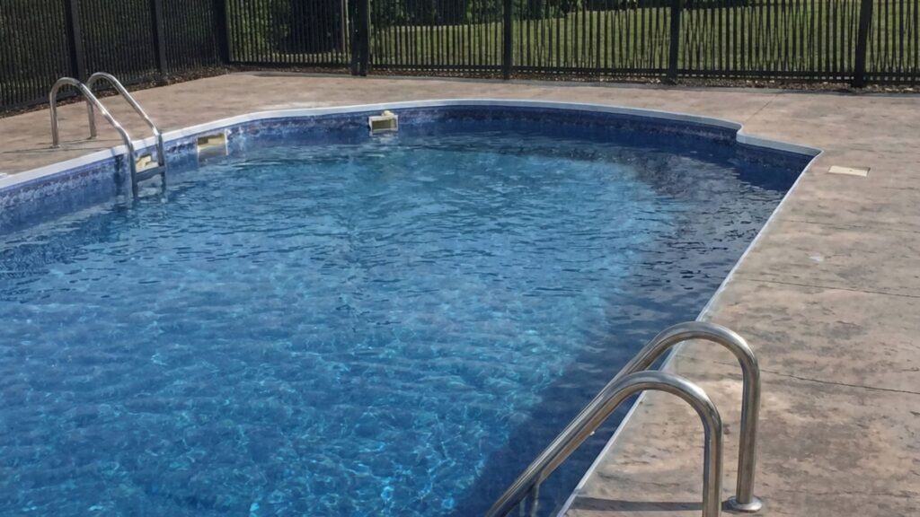 Residential swimming pool secured with black aluminum safety fence