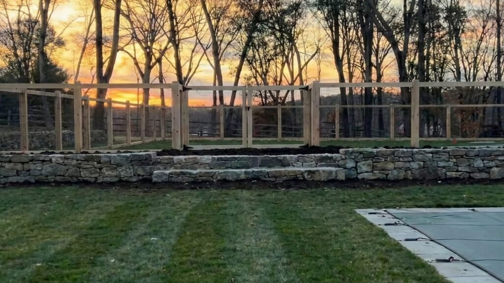 Custom wood fencing installed along a stone wall on a residential property in Connecticut